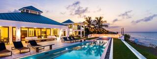 beachfront home with pool and firepit at sunset
